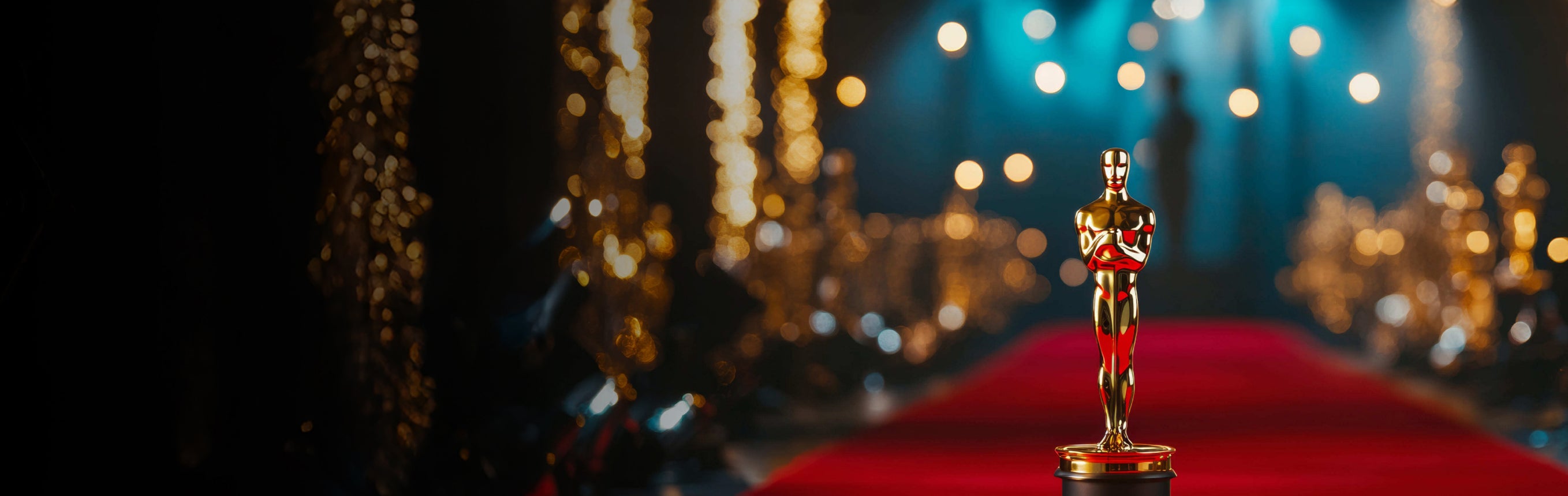 Oscar statue on a red carpet with blurred lights in the background