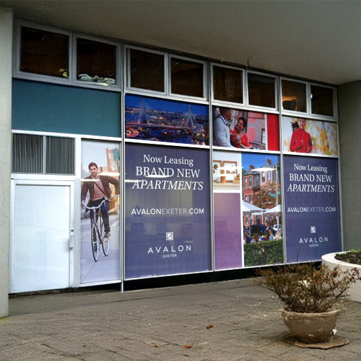 Real estate advertisement on a building facade with multiple windows.