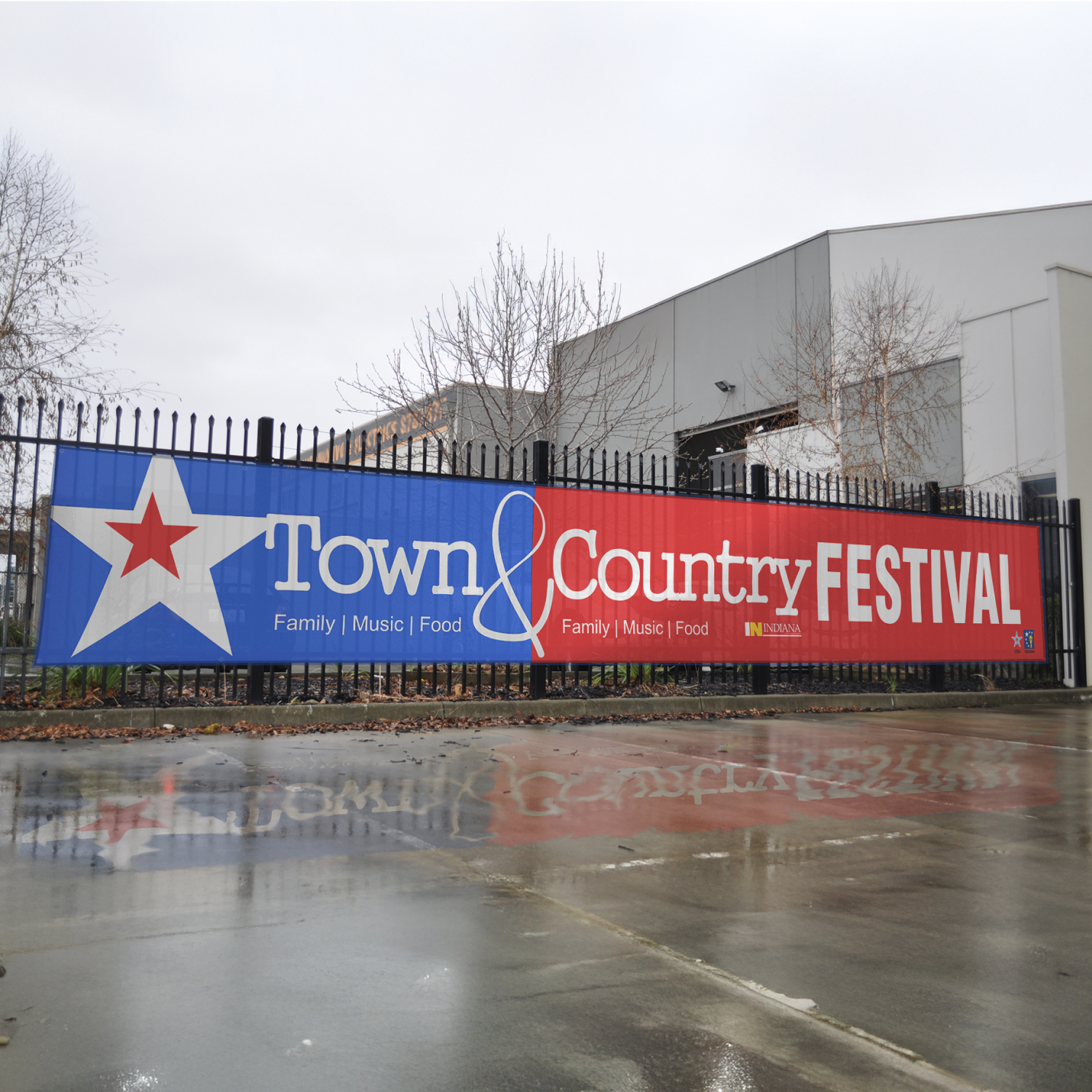 Large 'Town & Country Festival' banner on a fence with a building in the background.