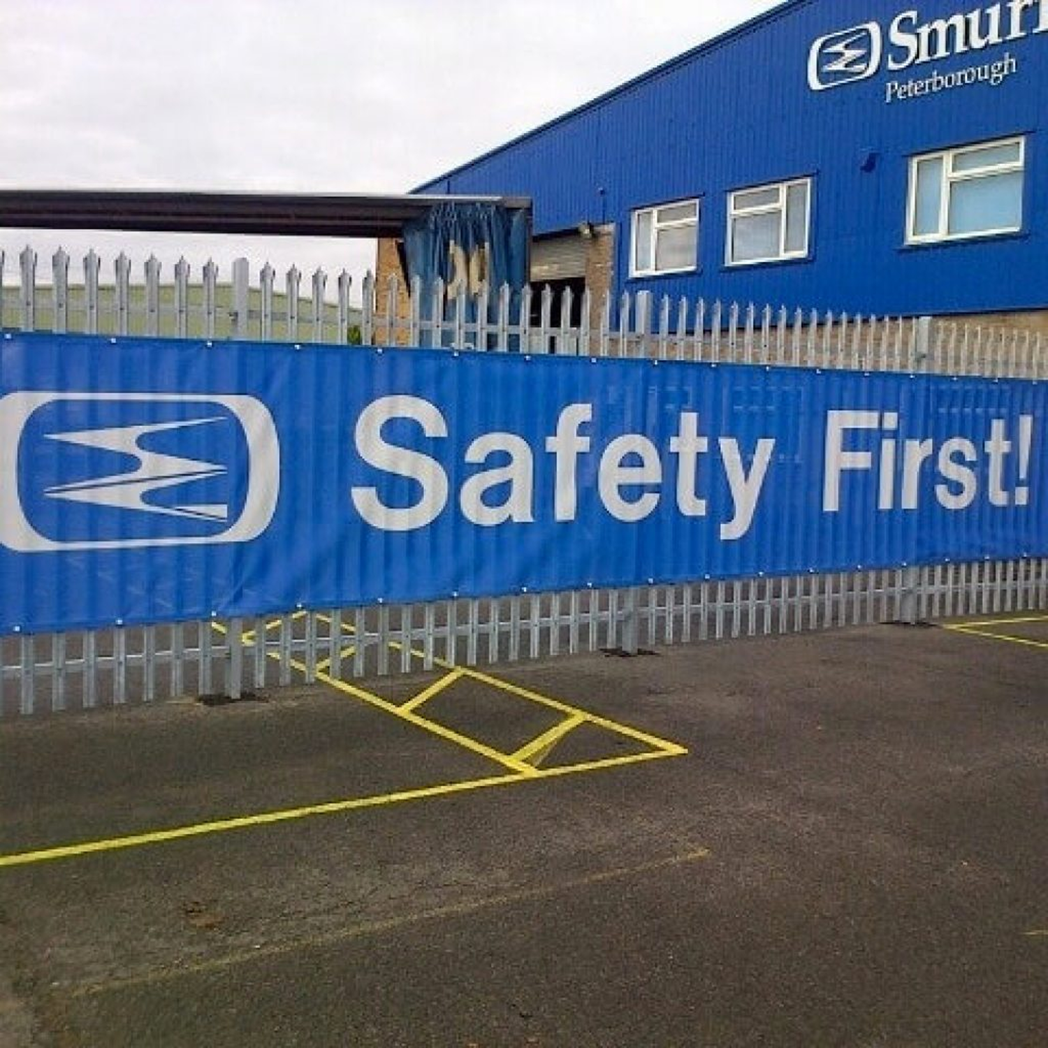 Blue banner with 'Safety First!' text in front of a building with Smurfit Kappa branding.