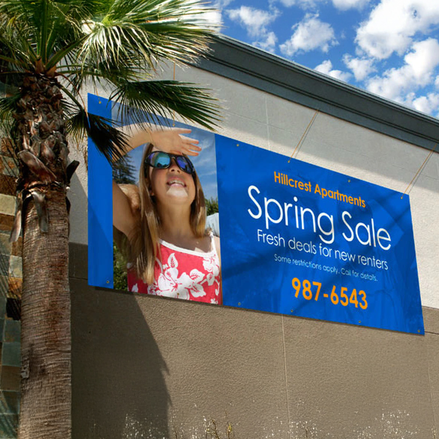 Hillcrest Apartments spring sale banner on a building with palm tree and blue sky.