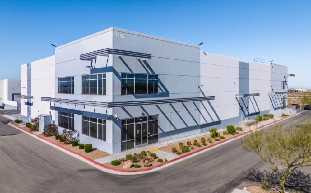 Modern industrial building with large windows and a flat roof on a clear day.