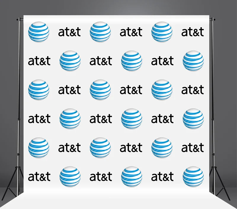 Repeating AT&T logo on a white backdrop with black stands.